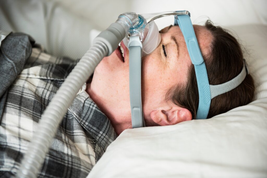 A woman sleeping with anti snoring chin strap